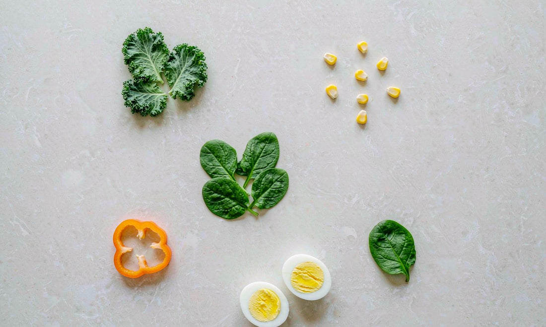 Overhead flat lay of kale spinach egg yolks pepper and corn rich in lutein and zeaxanthin