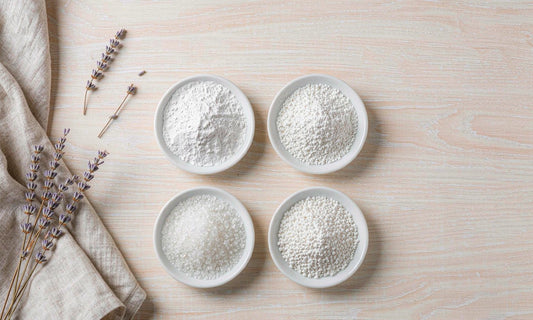 Four dishes of different magnesium powder forms arranged on a pale oak table with linen and lavender