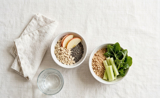 Overhead flat lay of oats, chia and apple beside bran, greens and celery on pale linen