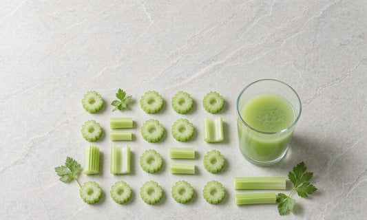 Fresh celery stalks and slices arranged in a precise grid pattern beside a glass of green juice