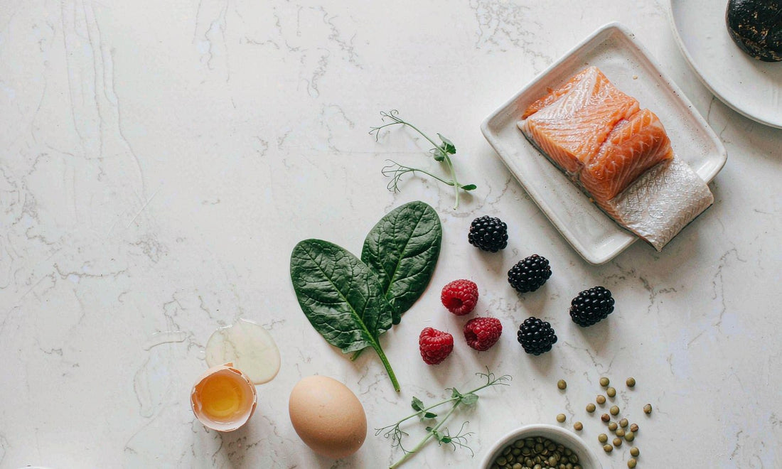 Flat-lay of salmon, eggs, seeds and berries that support hair and nail nutrients