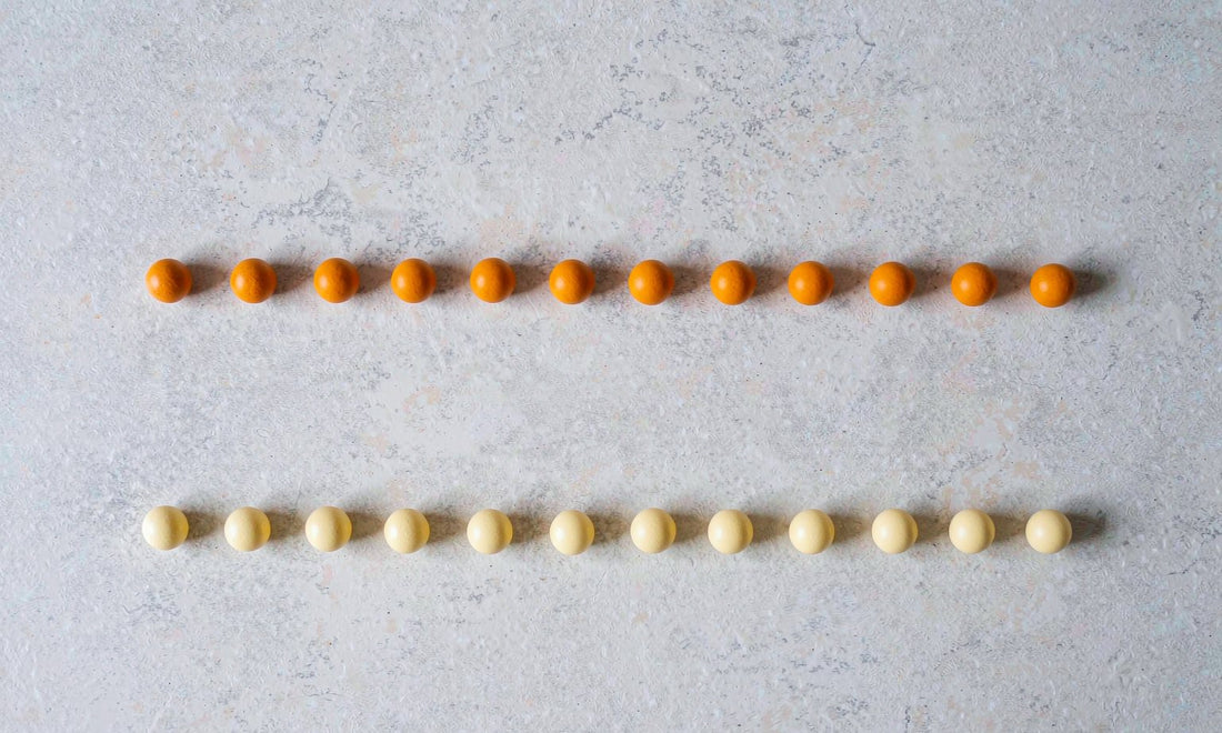 Top-down ingredient flat lay of two symmetric rows of small spheres in deep amber and pale gold.