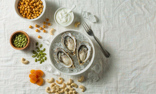 Overhead spread of zinc-rich foods with fresh oysters, pumpkin seeds, chickpeas and cashews